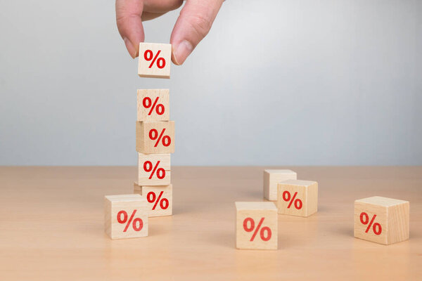 Концепция процентной ставки по финансовым и ипотечным ставкам. Ручная кладка блока деревянного куба увеличивается сверху с иконкой в процентах от направления вверх