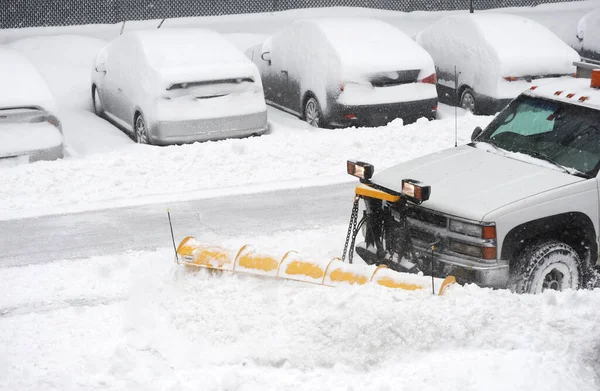 snowplow truck removing snow on the street after blizzard