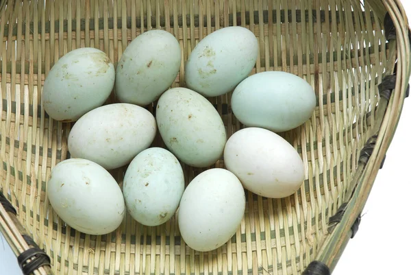 Bambu eleğindeki taze ördek yumurtaları beyaz arka planda izole edilmiş.