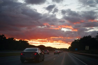   Otobanda gün batımında gökyüzünün altında arabalar                             