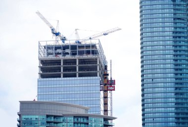  İnşaat alanında vinç ve inşaat halindeki gökdelen binası.                              