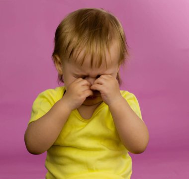 Çocuk ağlıyor ve gözlerini ovuyor.