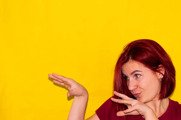 Sarı arka planda kızıl saçlı bir kız elleriyle bir yılan gösteriyor.