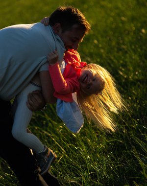 Mutlu baba oynuyor ve kızını omuzlarında taşıyor..