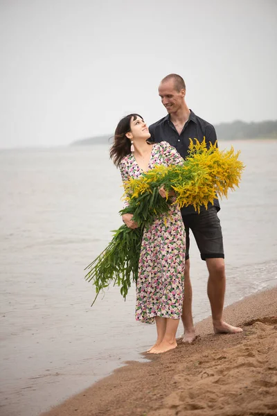 Unga Romantiska Par Med Stora Buketter Vilda Blommor Poserar Stranden — Stockfoto