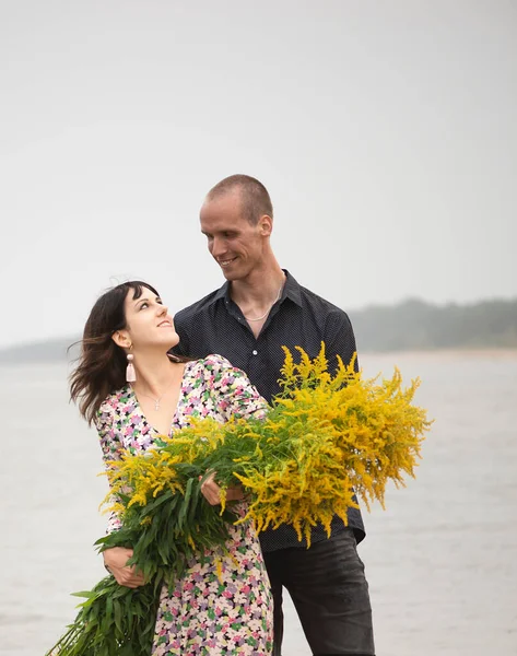 Unga Romantiska Par Med Stora Buketter Vilda Blommor Poserar Stranden — Stockfoto