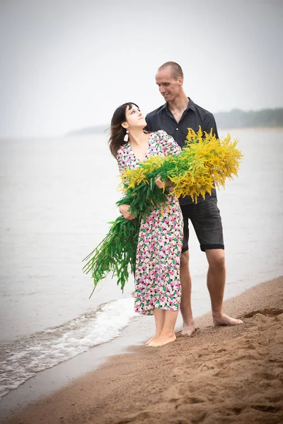 Unga Romantiska Par Med Stora Buketter Vilda Blommor Poserar Stranden — Stockfoto