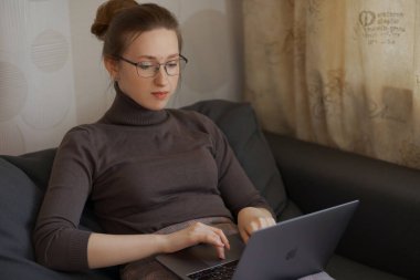 Güzel genç bayan internette ev işi yapıyor. Çevrimiçi eğitim. 