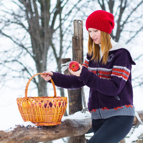 The beautiful blonde girl in red hat in the forest. Girl in winter. White snow. Little Red Riding Hood.