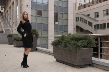 Siyah ceketli kız. Şehirdeki güzel, duygusal genç kız. Güzel kız elleriyle saçını tutuyor. Düşünen kadın. Çok düşünceli bir kadın. Bir insanın üzerinde şal ya da mendil. Kibirli görünüm