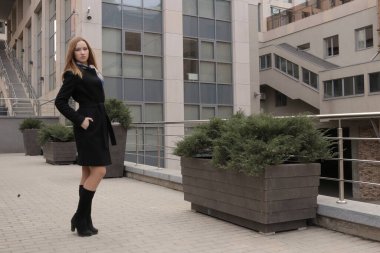 Siyah ceketli kız. Şehirdeki güzel, duygusal genç kız. Güzel kız elleriyle saçını tutuyor. Düşünen kadın. Çok düşünceli bir kadın. Bir insanın üzerinde şal ya da mendil. Kibirli görünüm