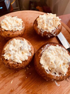 Peynirli mantarlar ahşap masada.