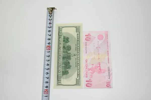 10个土耳其里拉钞票和100美元钞票在一个轮盘赌的背景下 用来衡量货币的重要性和尺寸 — 图库照片