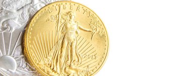 Sol tarafta closeup gümüş kartal ve american eagle altın bir ons sikkeler beyaz arka plan üzerine yerleştirilen