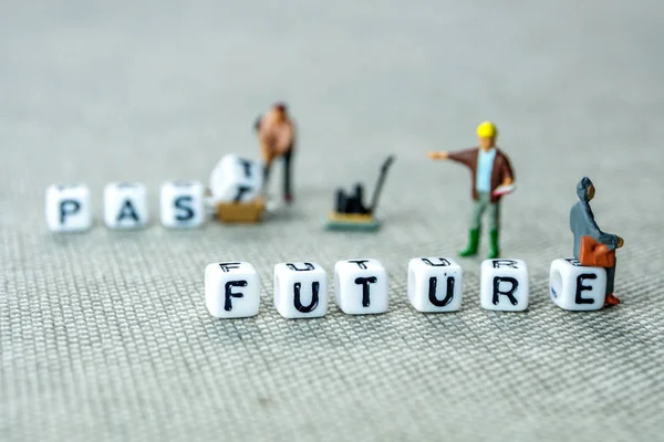 personal development and career growth or leting the past and be heading to the future concept in order to achieve set goals, grey background with miniature figurines watching at it
