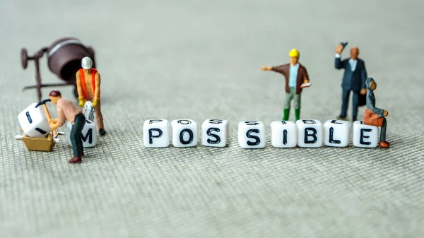 personal development and career growth or make possible concept in order to achieve set goals, grey background with miniature figurines watching at it