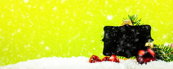 ジングルベルと針緑の背景に降る雪とクリスマスの装飾のクローズ アップ — ストック写真
