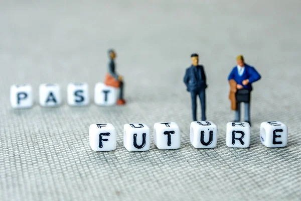 personal development and career growth or leting the past and be heading to the future concept in order to achieve set goals, grey background with miniature figurines watching at it
