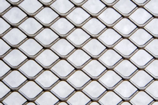 closeup of silver grey color metal wire mesh fence with light grey background shade