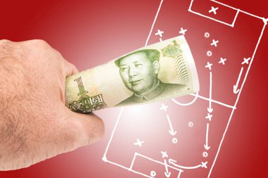 a man holding chinese yuan banknote with the picture of soccer footbal filed with play tactics and strategy drawn on red background clipart