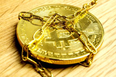 Altın bitcoin altın zincirleri ahşap arka plan üzerinde döşeme closeup