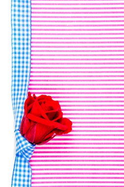 pembe ve beyaz çizgiler arka plan bir kırmızı kırmızı gül ve mavi düğüm ve bant ile kutlama veya Sevgililer hediye kartı ve bol metin için yer kopyalayın