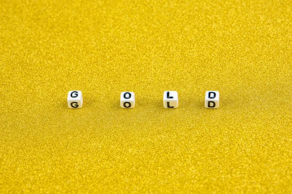 gold word formed by white dices with black letters  laying in the middle part of golden background