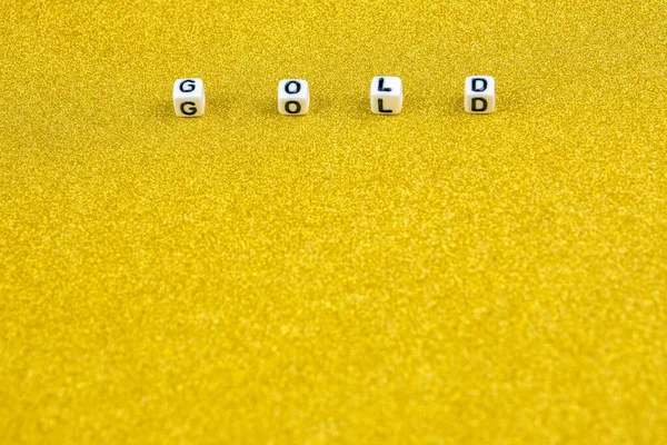 gold word formed by white dices with black letters  laying in upper part of golden background