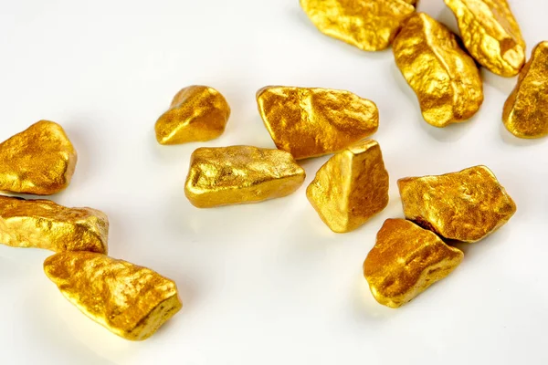 view of a heap of golden nuggets, golden ore on white background isolated with plenty copy space