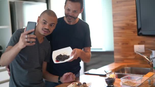 ゲイのカップル チョコレート調理後ビデオ チャットを作る キッチンでブリガデイロ — ストック動画