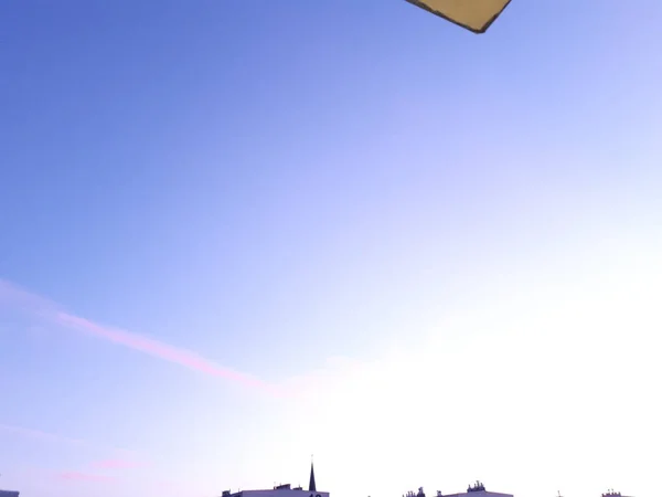 Açık mavi gökyüzüne karşı binaların siluetleri