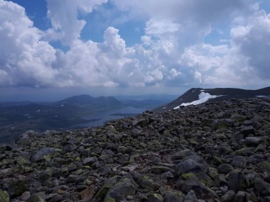 Gökyüzüne ve suya bakan dağ manzarası