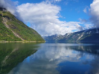 Gökyüzünün ve dağların yansıması fiyordun mavi suyunda - Eidfjord