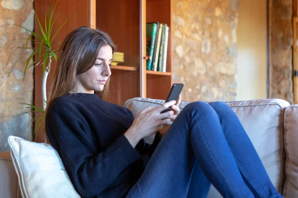 Seriöse Brünette Junge Frau Chat Mit Dem Smartphone Hause Auf — Stockfoto