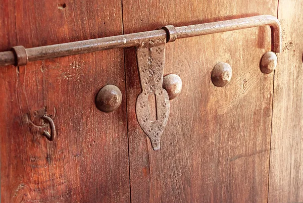 Old wooden door with vintage metal decoration latch. Arabian style. Toned photo. Selective focus.