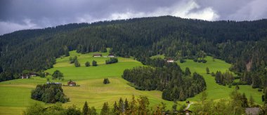 Güney Tirol 'ün PusterValley (Alto Aldige) yakınlarında, Innichen (San Candido), İtalya' da bir tepe yamacında dağ çiftlikleri bulunan bir çiftlik manzarası.