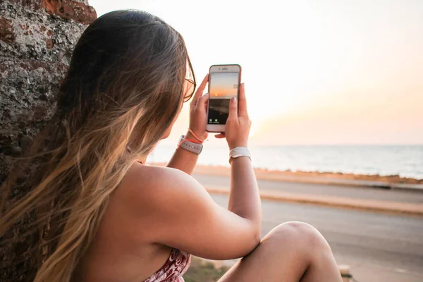 Cep telefonlu genç bir kadın selfie çekiyor.