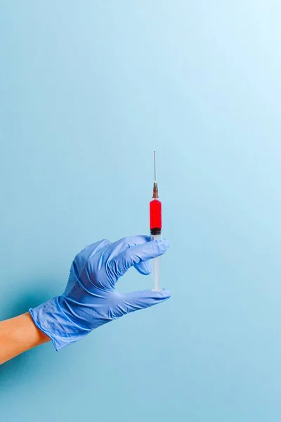A syringe hold by a hand with cover