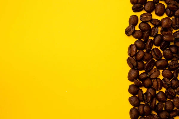 Coffee beans on a yellow background, room for text