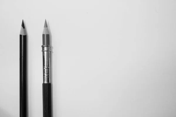 Beyaz arka plana karşı iki kalem, metin için yer