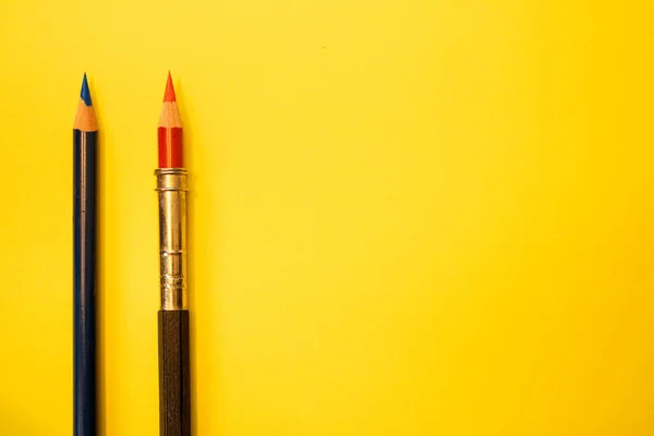 Sarı arkaplana karşı iki renkli kalem, metin için yer