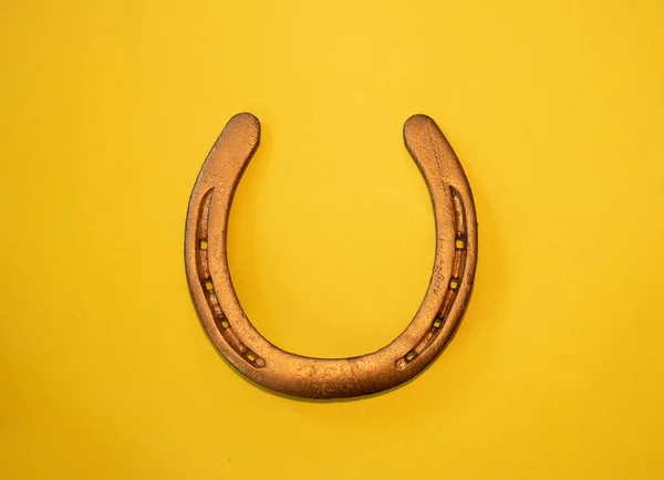Sarı arka planda altın bir at nalı