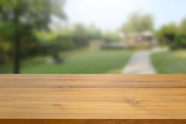空木製テーブルの上緑自然と木の背景をぼかした写真に対して 表示に使用または製品広告をモンタージュ — ストック写真