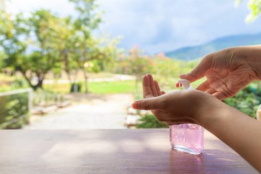 Alkol jeline bastıran bir kadının güzel eli dağlar ve gökyüzü manzaralı.