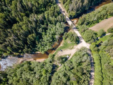 drone görüntü. güneşli günde orman yolu ile kırsal alan hava görünümünü. Letonya