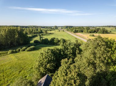 Drone görüntü. alanları ve bulutlu bahar günü ormanlarda kırsal alan hava görünümünü. Letonya