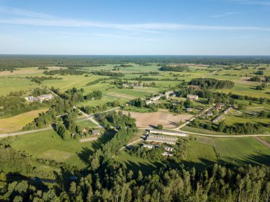 Drone görüntü. alanları ve bulutlu bahar günü ormanlarda kırsal alan hava görünümünü. Letonya