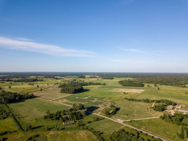 Drone görüntü. alanları ve bulutlu bahar günü ormanlarda kırsal alan hava görünümünü. Letonya