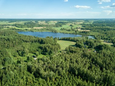 Drone görüntü. alanları ve bulutlu bahar günü ormanlarda kırsal alan hava görünümünü. Letonya