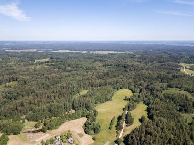 Drone görüntü. alanları ve bulutlu bahar günü ormanlarda kırsal alan hava görünümünü. Letonya